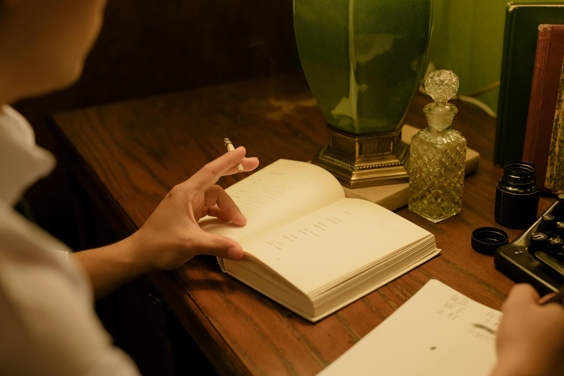man smoking and writing on his notebook